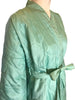 Closeup side view of mannequin in a 1960s light turquoise quilted robe