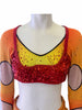 Top of consume set adorned with rhinestones over an orange to yellow gradient fabric and a red sequined bralette sewn on top 