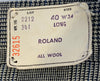Closeup of tag on a pair of deadstock 1960s mens trousers. The tag says "Size 40 W34 Long"  "Roland All Wool" "Lot2212 341 32615"