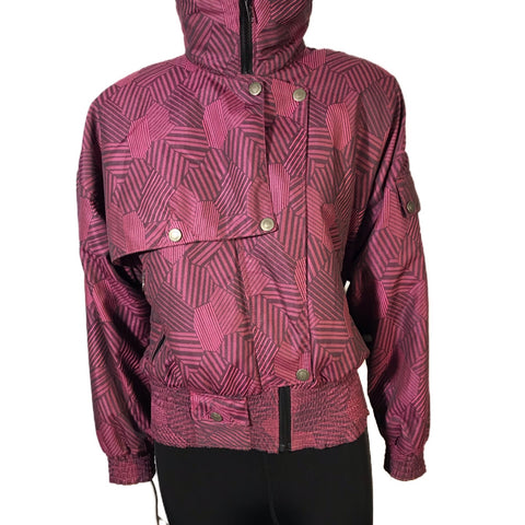 Magenta and black abstract patterned ski jacket. Asymmetrical snap front and high zip up neck.  Banded bottom 