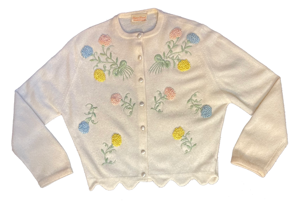 beige knit cardigan sweater with pink, yellow and blue embroidered flowers on it