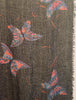 Oversized Black and metallic woven scarf with a print consisting of red and purple butterflies and a frayed hem