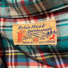 View of Robin Hood Sportswear tag-Green, red, yellow and black plaid button down with two front chest pockets