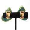 Back view of gold clip-on earring backs on green sculptural shell shaped earrings.