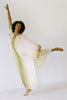 Woman balancing on one foot with one arm pointed upwards, wearing a 1970's Halston Kaftan