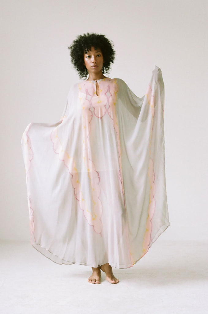 Woman holding the sides of 1970's hand dyed Halston Kaftan 