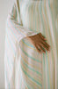 Woman's hand resting across her stomach, draped in a 1970's Halston Kaftan 