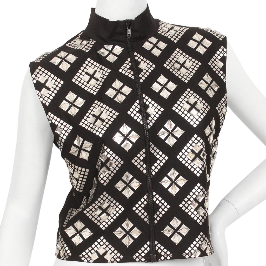 Black, sleeveless, zip-up, mock-neck top with a silver, graphic print with mirrored embellishments. 