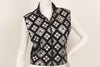 Black, sleeveless, zip-up, mock-neck top with a silver, graphic print with mirrored embellishments. 