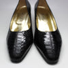 Front view of black snakeskin shoes with square toes.