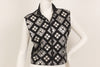 Black, sleeveless, zip-up, mock-neck top with a silver, graphic print with mirrored embellishments. 