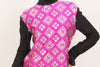 Fuschia shirt with black long-sleeves, black mock-neck, and a silver, graphic print with mirrored embellishments. 