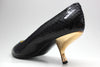 Anterior view of black snake skin shoes with 2 and a quarter inch gold comma heels