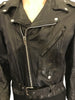 black leather motorcycle style jacket with zipper front and attached belt at waist. with three pockets on front.