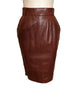 Front view on mannequin a two piece skirt and jacket in burgundy leather Jacket has gold studs on collar and front pockets. Skirt is straight and knee length. 