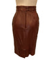 two piece skirt and jacket in burgundy leather Jacket has gold studs on collar and front pockets. Skirt is straight and knee length.