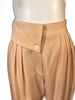 Closeup of fold over waistband on women's apricot colored trousers