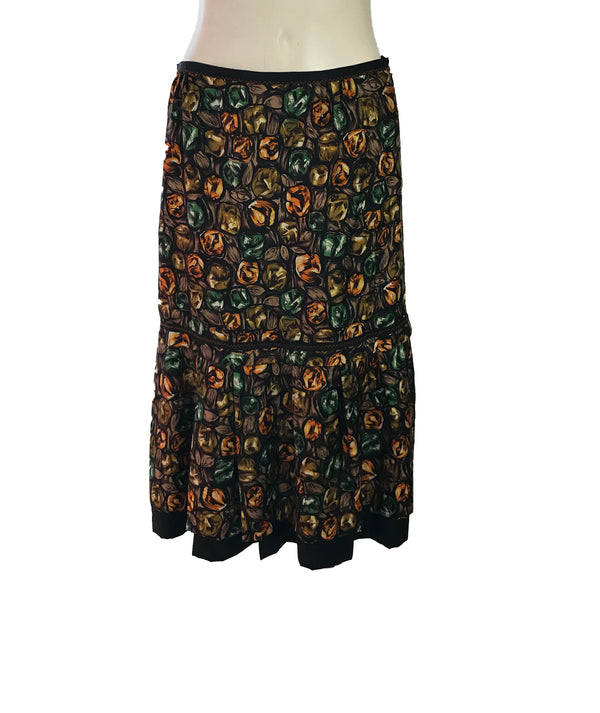 Front view of Easton Pearson silk skirt with a green, orange, and brown gemstone print.. 