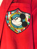 Patch with Mickey Mouse's face in front of a mix of international flags