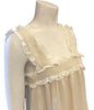 (bust close up of dress only) A sleeveless, straight cut, square neck, maxi dress with hidden side pockets and trimming around neckline and bottom hem in an off-white floral lace