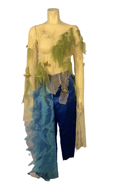 Two-piece set. Fishing-net shirt with extra-long sleeves, and green fabric & gold fish attached to the netting. Blue, asymmetrical, cropped pants with light-blue “waves” of fabric attached to one leg. 