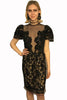 Short sleeve evening dress covered in lace and black beading. The front has a sheer insert. Skirt is knee length.