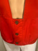 Red, button-up, utility vest with pockets, and a suede panel on one shoulder. Black buttons. 