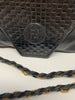 Fendi woven envelope bag in black leather with long braided shoulder strap . Fendi logo is embossed on the front.