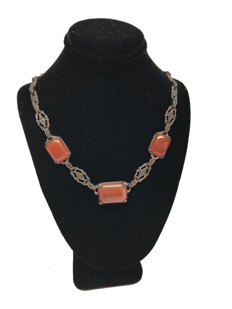 Front view of necklace display with a necklace featuring a decorative sterling silver and marcasite chain with three rectangular carnelian stones
