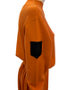 Orange, knit, long-sleeve, mock-neck sweater with black, “Junior Gaultier” patch on sleeve and a matching, orange, knit, knee-length, pleated skirt. 