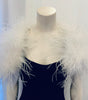 Shoulder shrug in white feathers lays across shoulders 