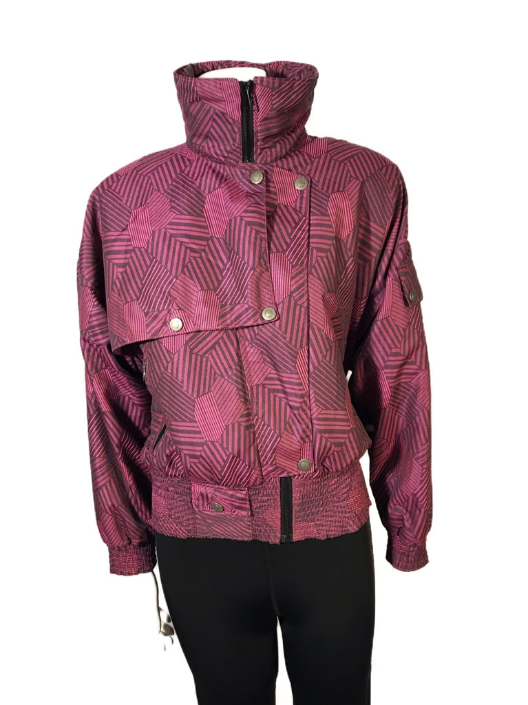 Magenta and black abstract patterned ski jacket. Asymmetrical snap front and high zip up neck.  Banded bottom 