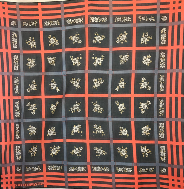 Emanuel Ungaro scarf with a black background and oversize windowpane plaid motif in coral and grey-blue. In the squares of the plaid, there are small clusters of blue and white flowers.