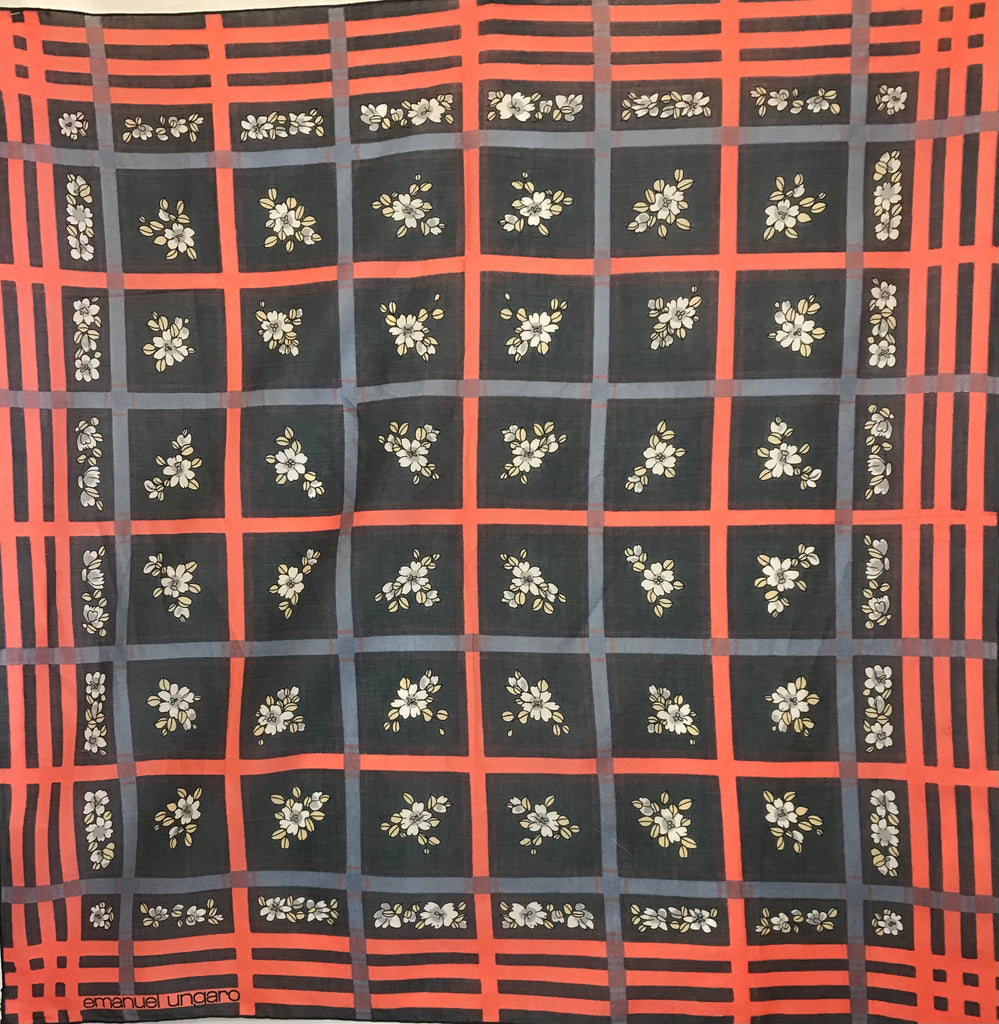 Emanuel Ungaro scarf with a black background and oversize windowpane plaid motif in coral and grey-blue. In the squares of the plaid, there are small clusters of blue and white flowers.