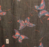 Oversized Black and metallic woven scarf with a print consisting of red and purple butterflies.