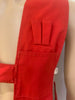 Red, button-up, utility vest with pockets, and a suede panel on one shoulder. Back of the vest is white, sports mesh. 