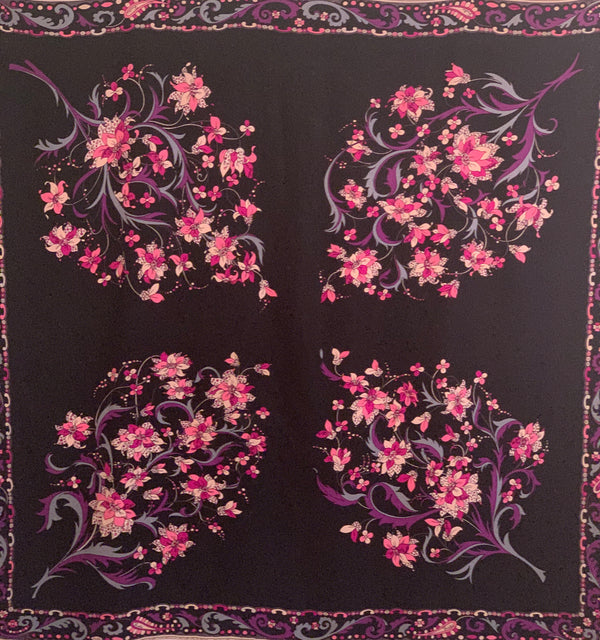 Black silk square scarf  with four floral  patterns in pink, purple, blue. and white. Border is a paisley pattern in a matching color scheme.