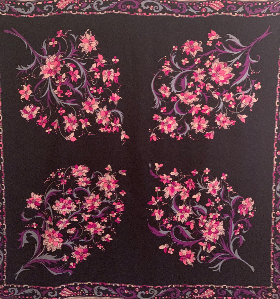 Black silk square scarf  with four floral  patterns in pink, purple, blue. and white. Border is a paisley pattern in a matching color scheme.