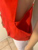 Red, button-up, utility vest with pockets, and a suede panel on one shoulder. Back of the vest is white, sports mesh. 