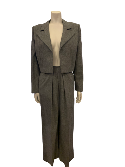 Two piece suit with pleated pants in a grey wool. Jacket has a pleated open front. Pants are full. 