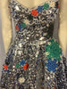 Silver paillette, fit & flare, sleeveless dress with blue, red, green, & white, round, rhinestone appliques. Silver, pleated underskirt. 