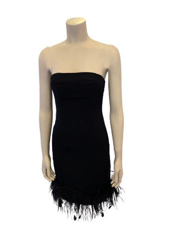Black strapless form fitting evening dress with feather trimmed hem. Knee length 