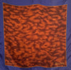 Small square silk pocket scarf  with a blue border, mottled brown center pattern and the word BELAMI on the right bottom corner. 