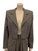 Two piece suit with pleated pants in a grey wool. Jacket has a pleated open front. Pants are full.