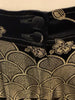 Black-and-gold, silk, brocade, high-waisted pant with floral motif on front top and on legs.