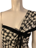 Black and white, dot-print, mesh top with an asymmetrical single sleeve and black bow. 