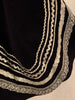 Closeup of silver trim on a black skirt hem