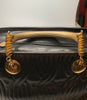 Black leather Fendi handbag with stitched leather body in a wavy pattern. The handles and hardware are in gold-tone metal and chain.