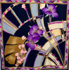 Square silk scarf with a pattern of geometric shapes and florals in black, brown, purple, blue, pink and creme