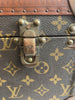 Large, hard, leather suitcase with an all-over “LV” monogram print. Brass hardware with "LV" stamp.